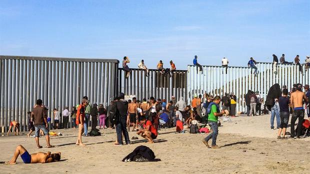 Migrantes trepan la valla que divide a México de EEUU