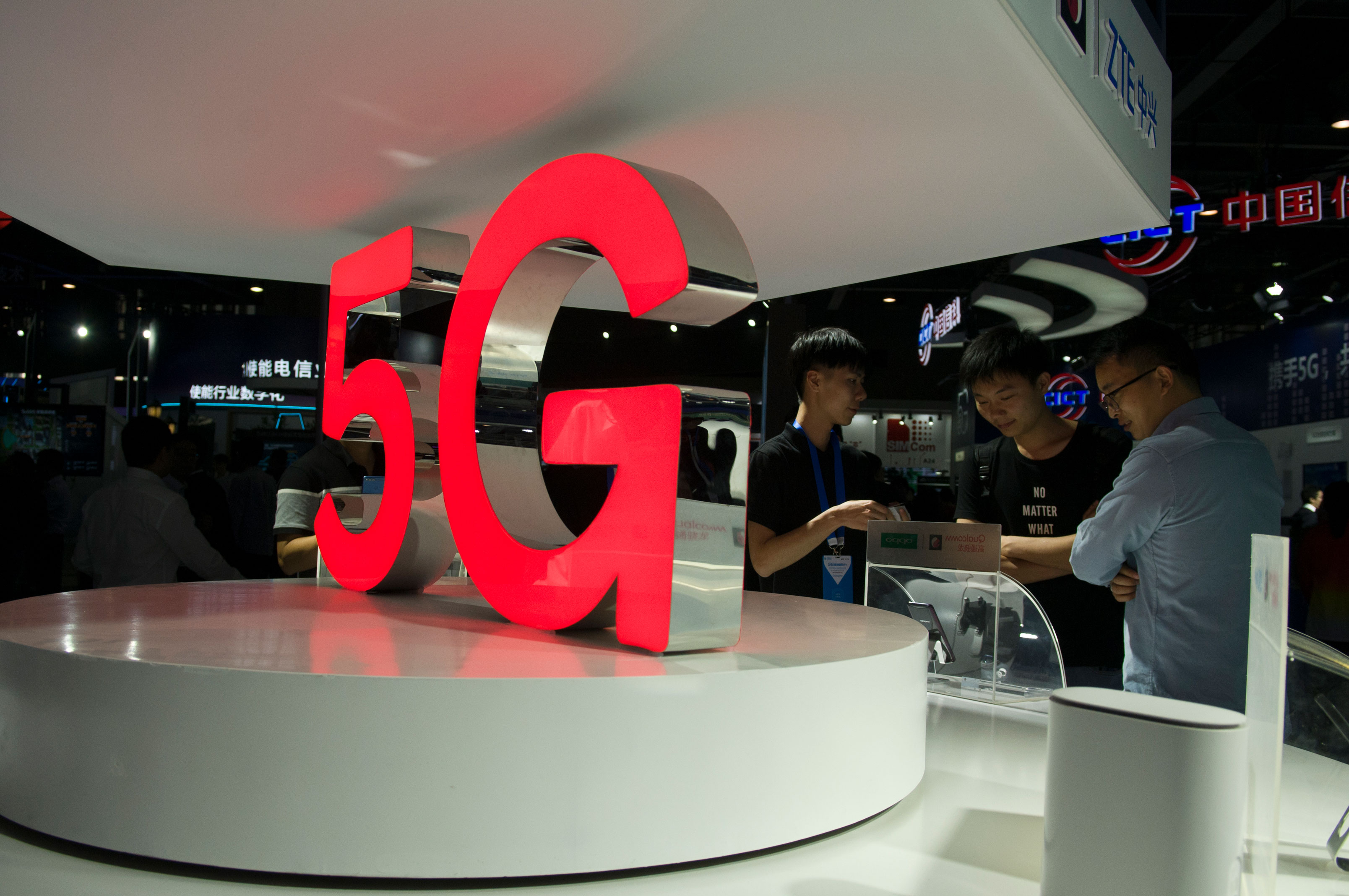 Los asistentes observan los teléfonos móviles 5G en el stand de Qualcomm durante la Conferencia Mundial de Socios Móviles de China 2018 en la Sala de Exhibiciones del Poly World Trade Center el 6 de diciembre de 2018 en Guangzhou, provincia de Guangdong en China.