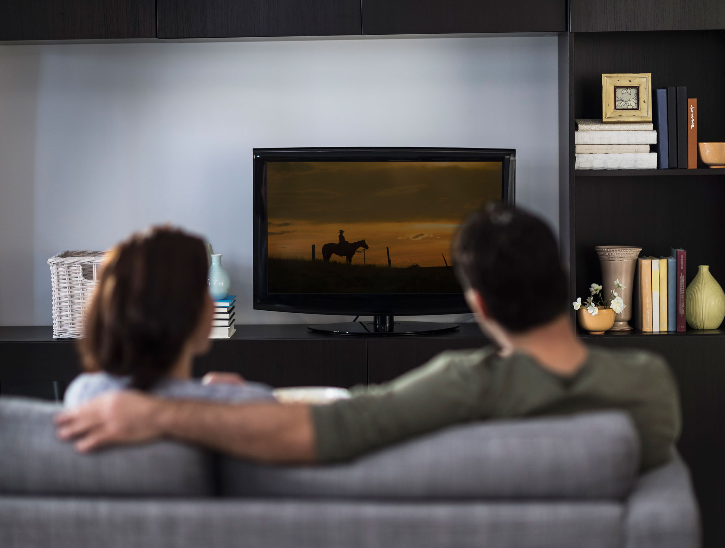 Pareja viendo la televisión en su sofá.