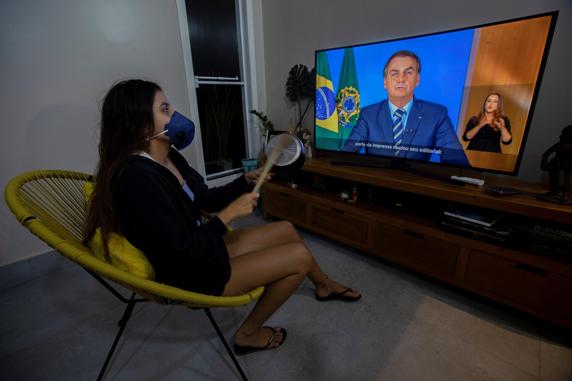 Una mujer con una máscara protesta golpeando una olla durante una declaración televisada del presidente de Brasil, Jair Bolsonaro FORO: EFE