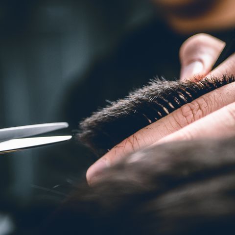 Torso del hombre cortando el cabello en el peluquero