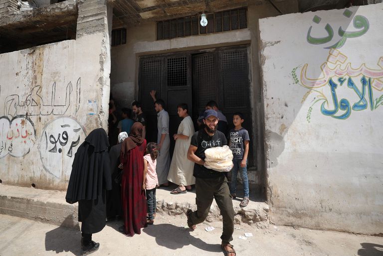 Unos sirios compran pan el martes en la localidad de Binnish, en la provincia de Idlib y bajo control insurrecto.
