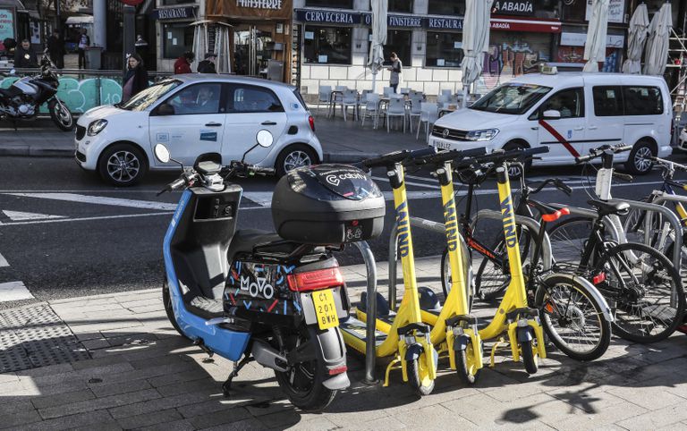 Patinetes, motos eléctricas y coches eléctricos de alquiler, en las calles de Madrid.