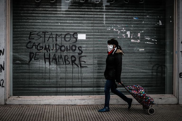 Una persona pasa frente a un comercio de la ciudad de Buenos Aires cerrado a causa de la crisis económica.