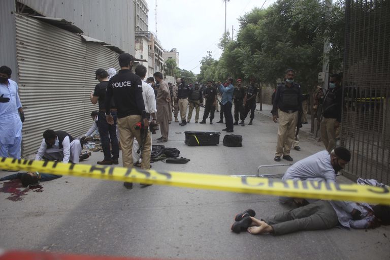 La policía examina los cuerpos de los terroristas que este lunes han atacado la Bolsa de Karachi (Pakistán).