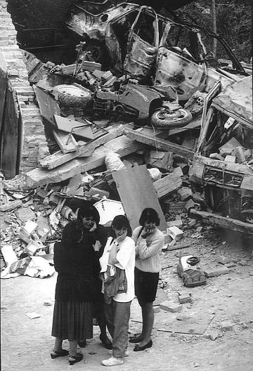 Familiares de los Guardias Civiles lloran, en mayo de 1991, ante los restos de la casa-cuartel de Vic (Barcelona), al día siguiente del atentado de ETA en el que murieron nueve personas, entre ellas, cinco menores. 