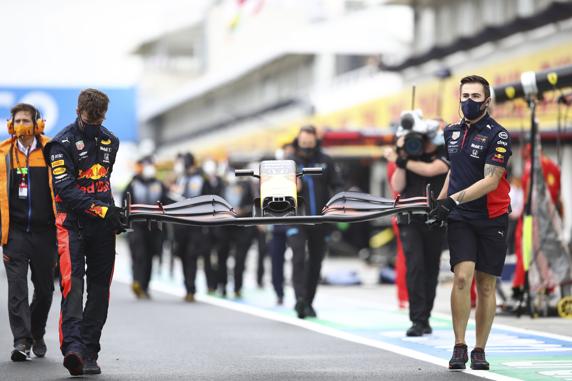 Los mecánicos de Red Bull, llevando un alerón nuevo a pista para montarlo en el coche de Verstappen en la parrilla