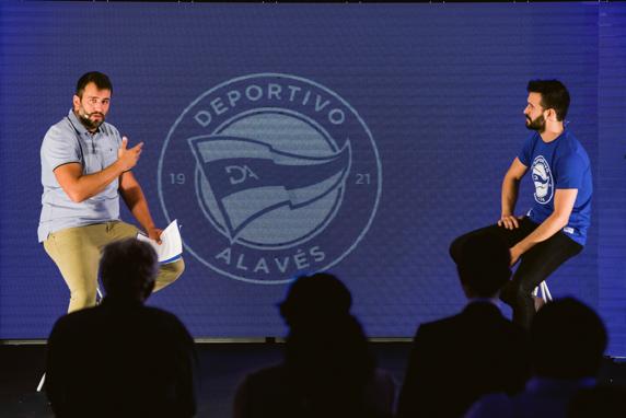 El diseñador Asier Samaniego (d) junto al presentador del evento, durante la presentación del nuevo escudo del Deportivo Alavés.