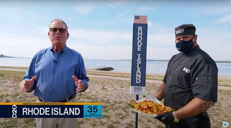El demócrata de Rhode Island Joseph McNamara posa junto a un cocinero con un plato de calamares.