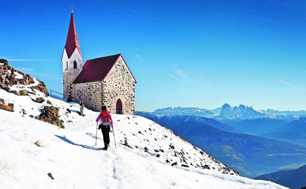 Una iglesia frente a la cadena montañosa de Los Dolomitas (Italia).