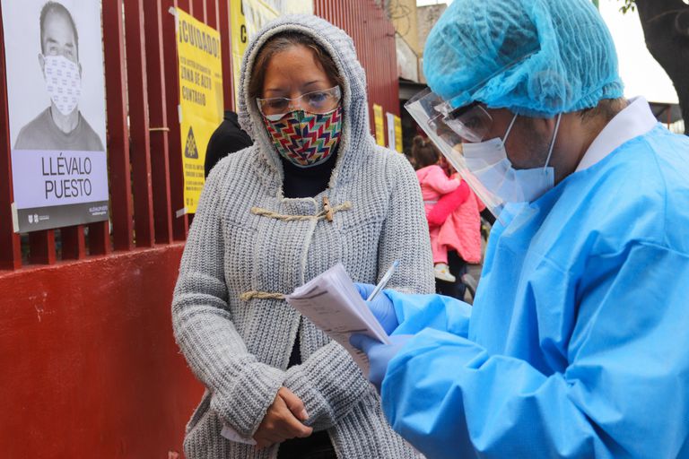Un trabajador sanitario recibe a personas para la prueba rápida de la covid-19, en uno de los nuevos quioscos instalados en Ciudad de México.