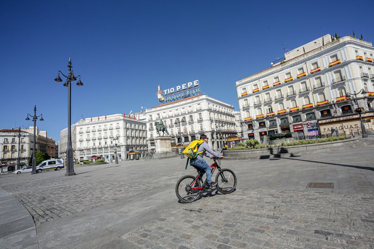 Un 'rider' de Glovo circula por la Puerta del Sol, en Madrid.