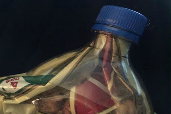 La parte superior de una botella sobre una bolsa de bocadillos. 