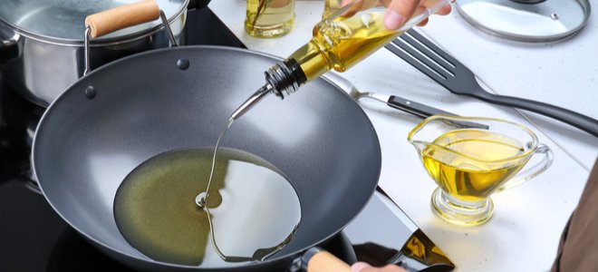 verter aceite en una sartén curva para cocinar