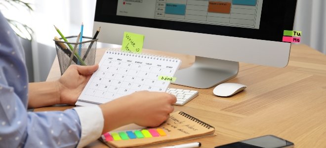 mujer organizando su calendario junto a una computadora