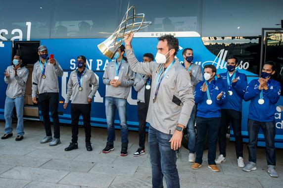Vitor Benite exhibe el trofeo al salir del autocar.