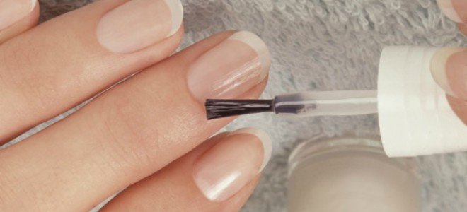 manos aplicando esmalte de uñas