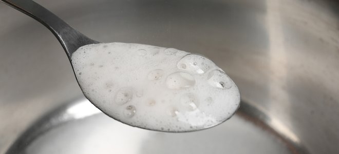 burbujas blancas en una olla de acero y cuchara de plata
