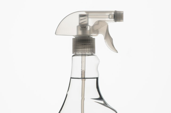 Una botella de spray transparente con líquido en su interior. 