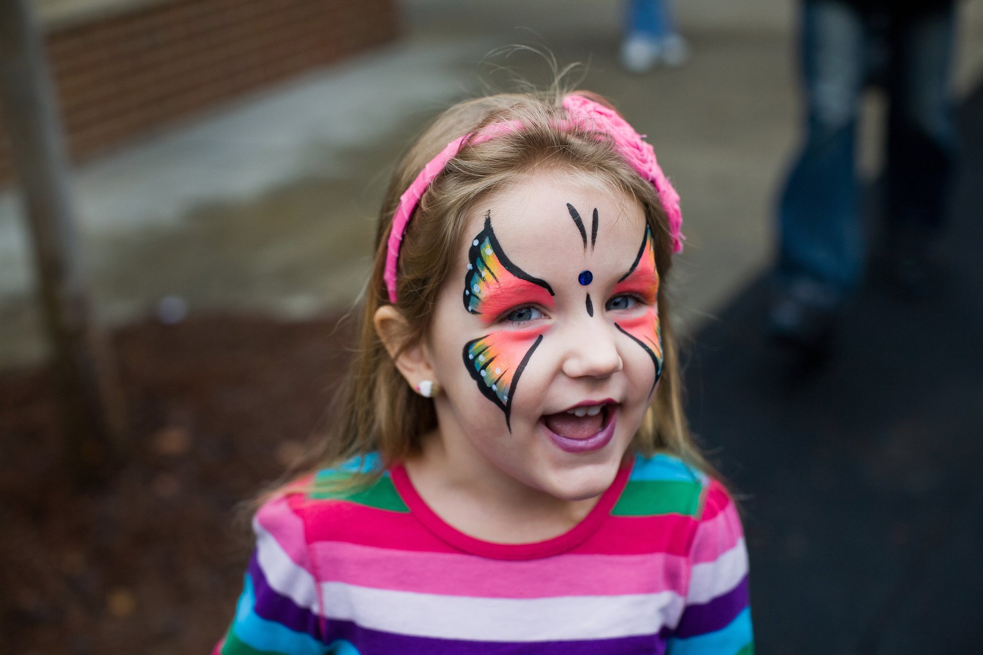 Una niña con pintura facial de mariposa.