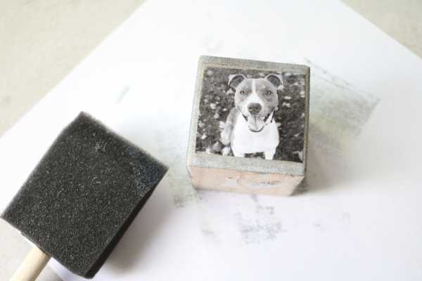 Aplicar una foto a un bloque de madera con una esponja negra. 