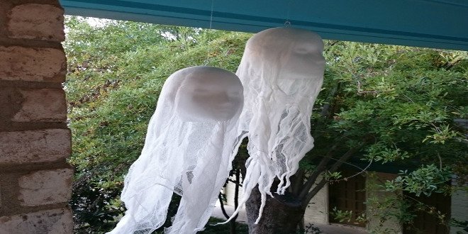 Un par de decoraciones de Halloween de cabeza flotante en un porche. 