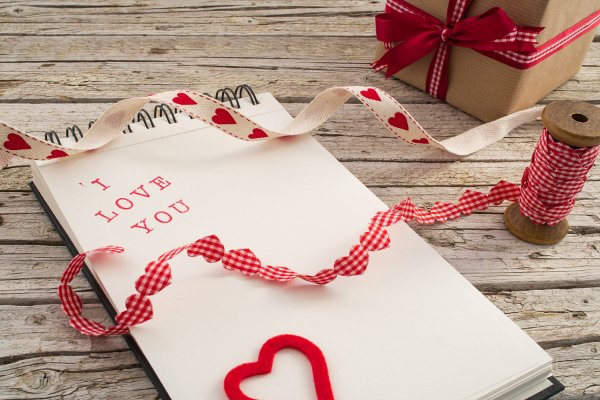 Un bloc de notas con materiales para manualidades del Día de San Valentín. 