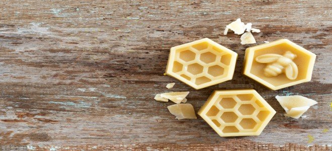 Un trío de cera de abejas sobre un fondo de madera rústica. 