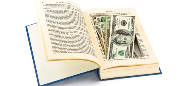 un libro con dinero metido en páginas talladas