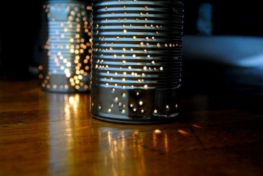 Un par de latas con agujeros perforados como diseño y luz brillando. 