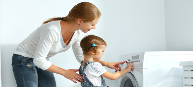 Una mamá lava la ropa con su hija.