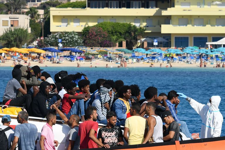 Migrantes de Túnez y Libia son examinados en un barco de la Guardia Costera italiana, el 1 de agosto en Lampedusa.