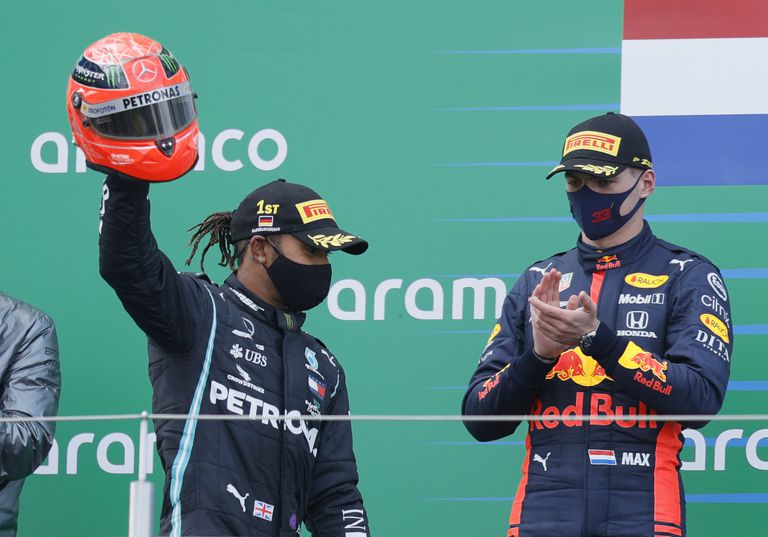 Hamilton, aplaudido por Verstappen, celebra el triunfo en Nurburgring alzando el casco de Michael Schumacher que le regaló el hijo del piloto alemán.