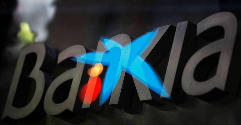 Fotografía de multiexposición que muestra los logotipos de las entidades bancarias Bankia y CaixaBank. 
