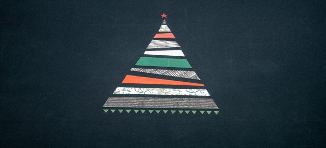 Un árbol de Navidad hecho de cinta washi sobre un fondo de pizarra negra. 