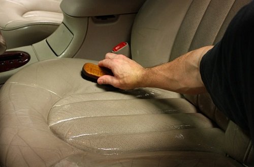 Cepillar un asiento para el automóvil con un cepillo para gamuza