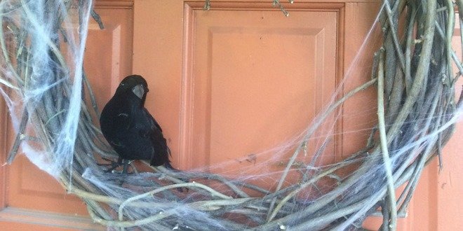 Una corona de Halloween en la puerta de entrada con pájaros negros. 