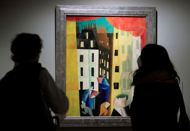 Dos visitantes observan el cuadro 'Arquitectura II', de Lyonel Feininger.