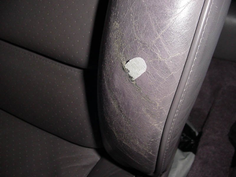 Pieza rota de asiento de cuero gris en un coche