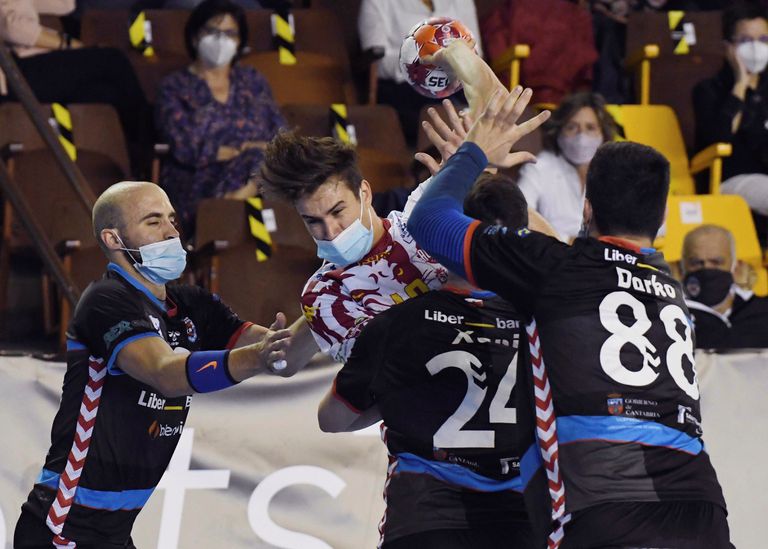 Pérez de Arce, de Ademar, ataca la defensa del Sinfín el pasado sábado en el primer partido de élite en España con mascarillas.