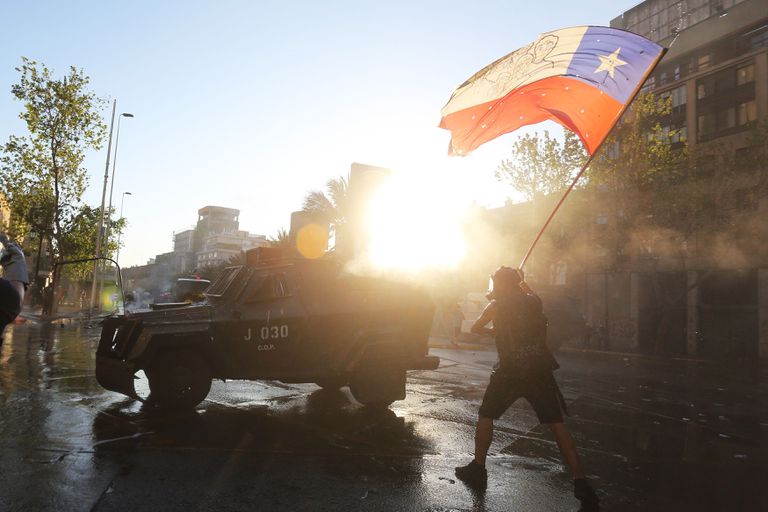Un manifestante ondea una bandera chilena, este viernes en una protesta en vísperas del plebiscito constitucional.