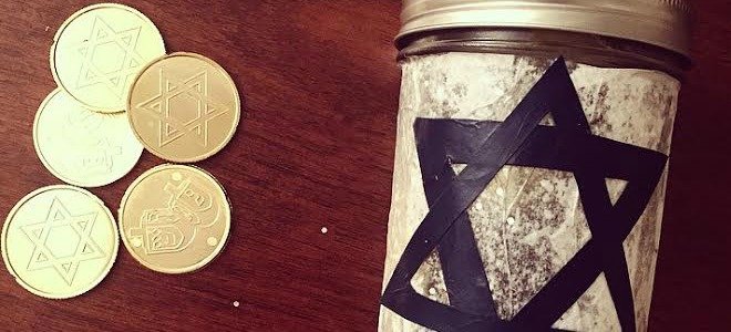 Un tarro de cristal con la estrella de David junto a algunas monedas de chocolate de Hanukkah.