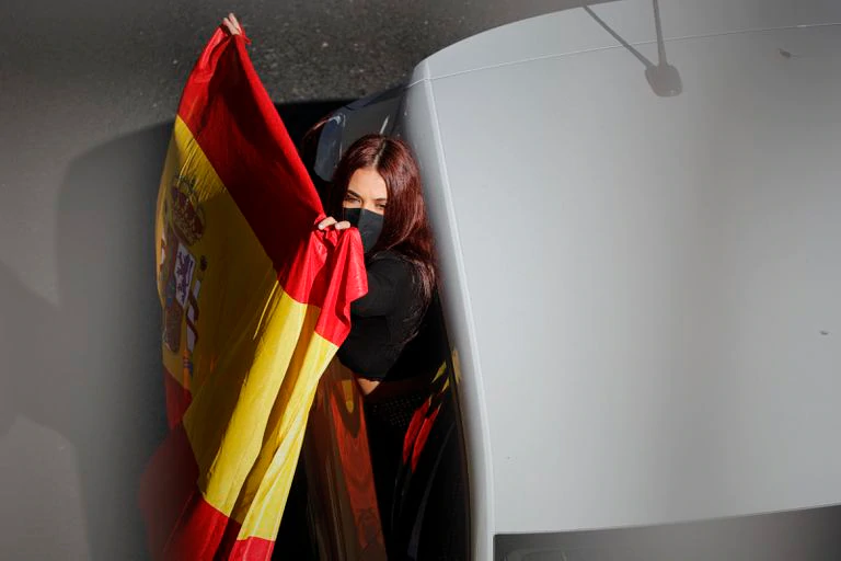 Una mujer exhibe una bandera durante la manifestación motorizada de Vox contra el Gobierno el pasdo día 12 por el centro de Madrid.