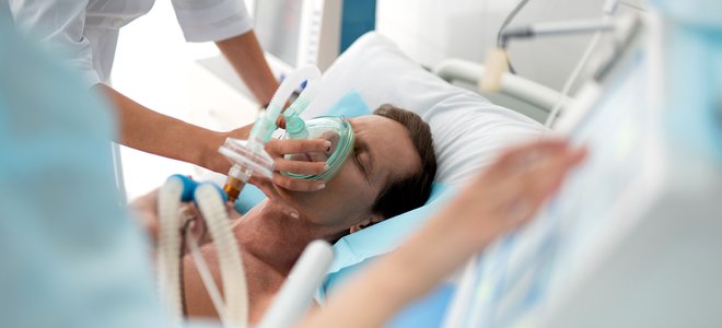 Hombre en el hospital con una enfermera aplicando ventilador