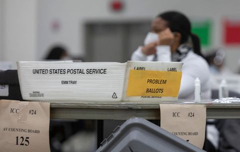 Los funcionarios electorales de Michigan procesan el correo en las boletas antes de las elecciones.