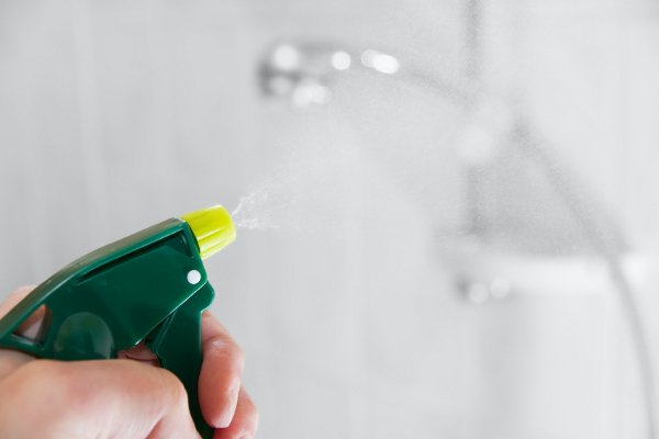 Una imagen de primer plano de una botella de spray en la ducha. 