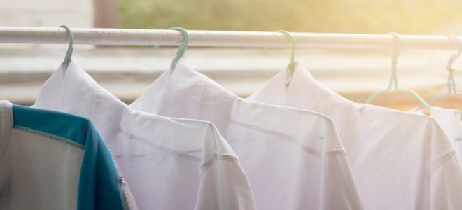 Camisas colgadas en una barra para secar en un cuarto de lavado. 