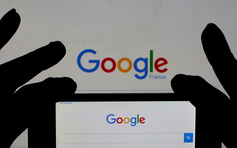 Foto de archivo de una mujer sosteniendo su teléfono con la página de inicio de Google