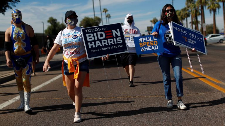 Varias personas promueven el voto, en Phoenix (Arizona) el 31 de octubre.