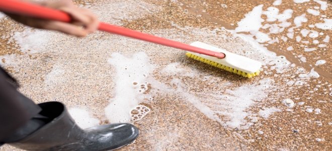 fregar un piso de baldosas con una escoba y agua jabonosa